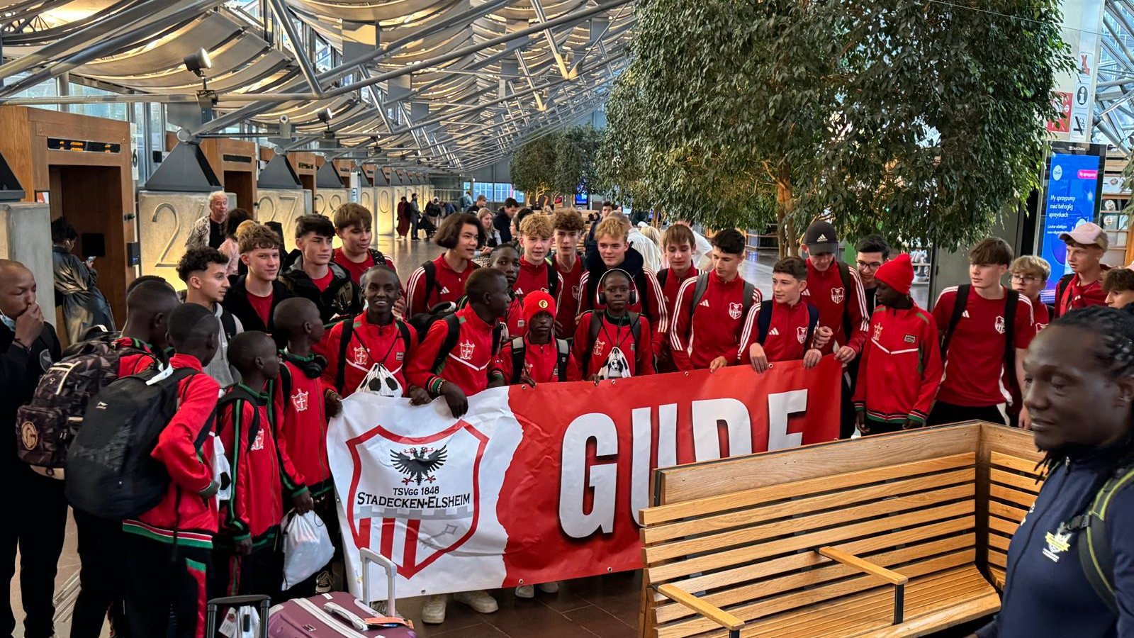 The TAFA touring squad with their luggage and a club banner at Gothenburg airport