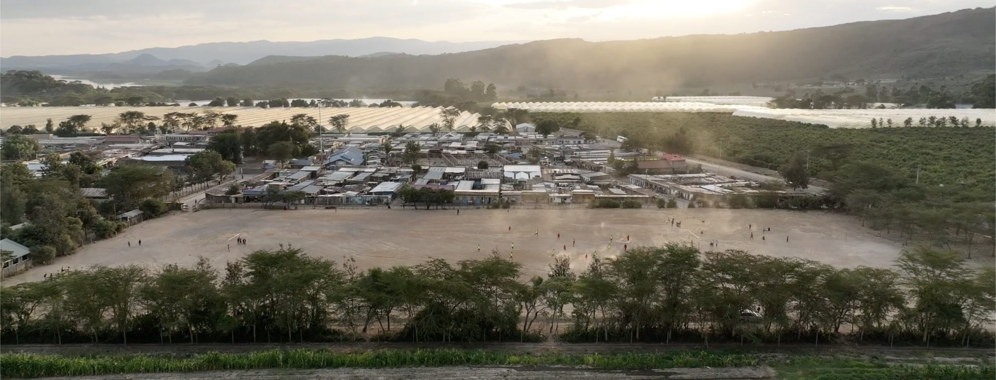 Kasarani in golden light: the community football pitch at the center of the settlement, Lake Naivasha beyond